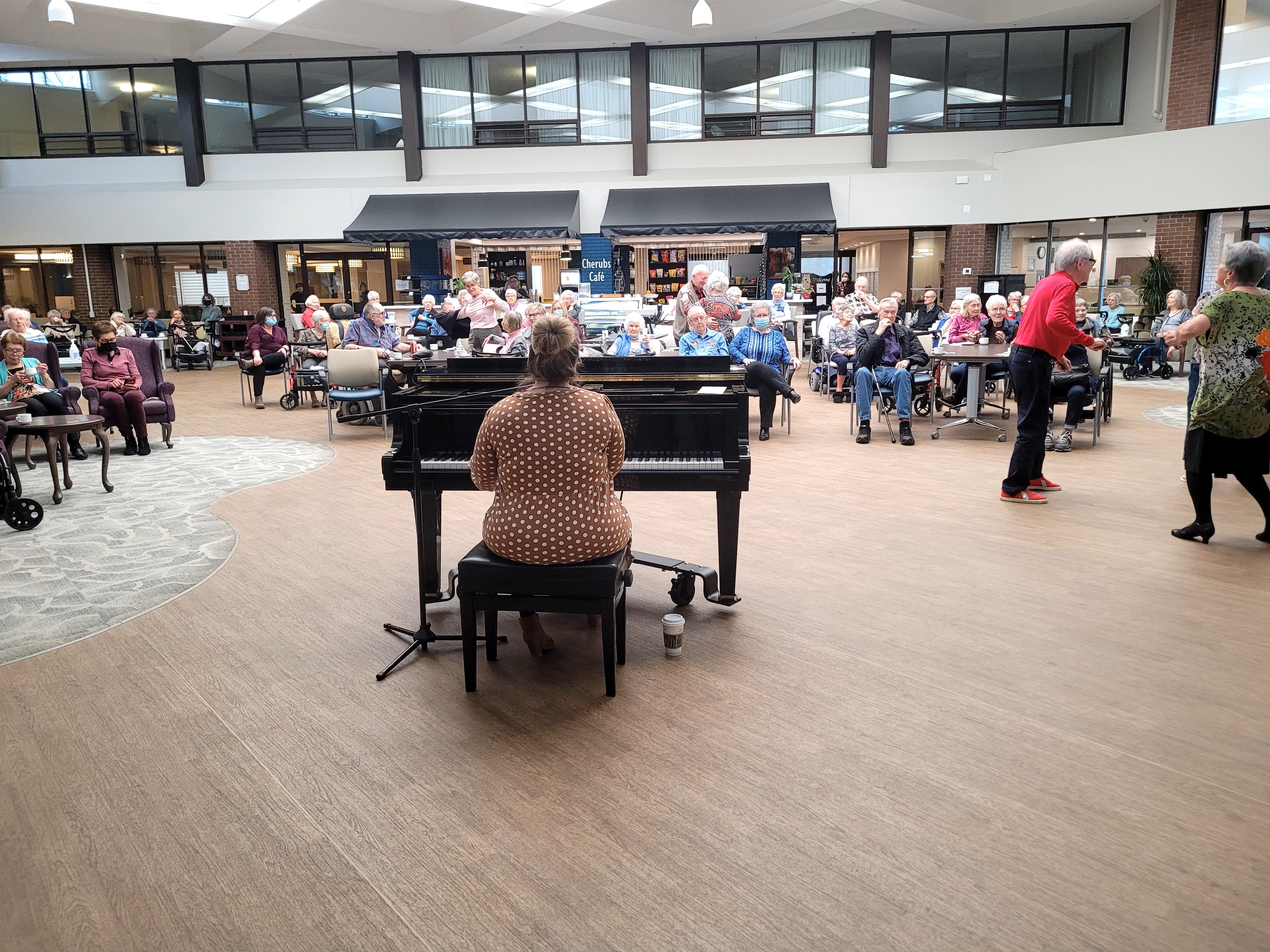 Residents enjoying a live piano performance at Canterbury Foundation